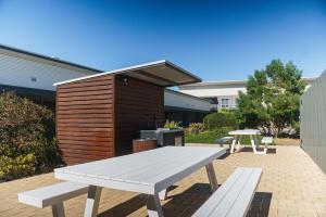 MainStay Suites Whyalla في وايالا: طاولة نزهة وشوية أمام المبنى
