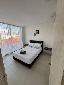 um quarto com uma cama e uma janela grande em Casa moderna con piscina privada Cabo Verde praia em Ricaurte