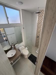 um banheiro com vaso sanitário, pia e chuveiro em Casa moderna con piscina privada Cabo Verde praia em Ricaurte