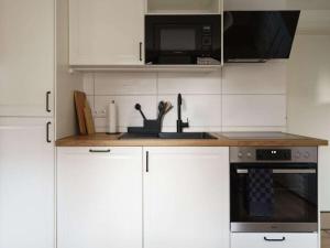 Holiday home Ahorn, 1st floor في Weilerswist: مطبخ مع دواليب بيضاء وميكرويف +12 صورة