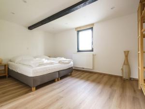 Holiday home Ahorn, 1st floor في Weilerswist: غرفة بيضاء بها سرير ونافذة