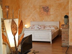 a bedroom with a white bed and a television at Holiday apartment with 1 bedroom in Furth im Wald