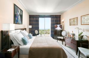 a hotel room with a large bed and a window at Hôtel Juana in Juan-les-Pins