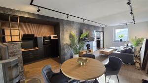 a living room with a wooden table and chairs at Ferienhaus-Kleine-Austernperle in Dornumersiel