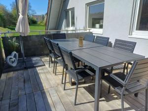 a wooden table and chairs on a patio at Holiday apartment with 1 bedroom in Herbstein