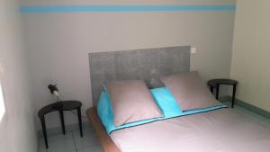 um quarto com uma cama com dois bancos pretos em La Forge Hébergement em Mouazé
