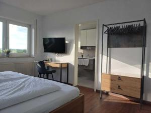 a bedroom with a bed and a desk and a television at Holiday apartment with 1 bedroom in Herbstein