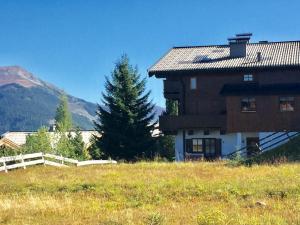 a house in a field next to a mountain at Holiday apartment with 1 bedroom in Königsleiten