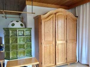 a wooden cabinet in a room with a table at Holiday apartment with 1 bedroom in Königsleiten