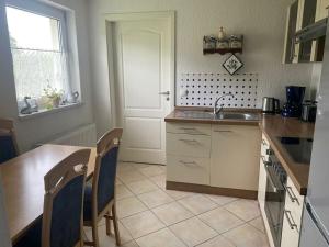 at the Gau family's home in Poggenhof في Charlottendorf: مطبخ مع حوض وطاولة وكراسي