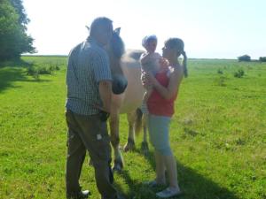 at the Gau family's home in Poggenhof في Charlottendorf: مجموعة من الناس يقفون في حقل مع ماعز +4 صور