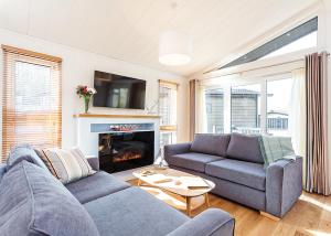 a living room with two couches and a fireplace at Woodside Bay Lodge Retreat in Wootton Bridge