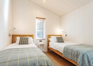 a bedroom with two beds and a window at Woodside Bay Lodge Retreat in Wootton Bridge +26 photos