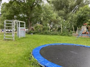 2 with large garden, playground and pool في Sommerstorf: منطقة لعب مع ترامبولين في الفناء
