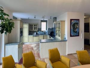 Una cocina grande con sillas amarillas y un mostrador. en Holiday home Cityhouse WG 9, en Marktheidenfeld