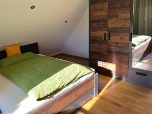 1 dormitorio con 1 cama con sábanas verdes y espejo en Holiday home Cityhouse WG 9, en Marktheidenfeld