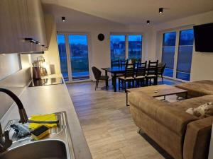 a kitchen and living room with a couch and a table at Holiday home Ebbe with dog up to 14 people in Schülp