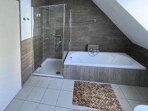 un baño con ducha y bañera en Holiday home Cityhouse WG 9, en Marktheidenfeld 26 fotos más