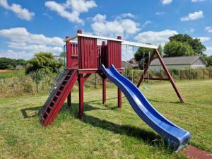 a playground with a slide and two slides at Holiday home Ebbe with dog up to 14 people in Schülp