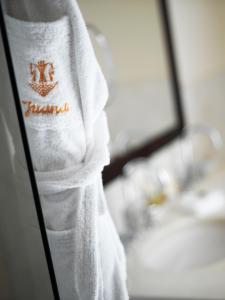 a white towel with a crown on it next to a sink at Hôtel Juana in Juan-les-Pins