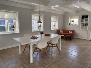 ein Esszimmer mit einem weißen Tisch und Stühlen in der Unterkunft Holiday home property 46 in Utersum