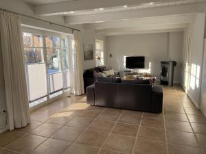 ein Wohnzimmer mit Sofa und Fernseher in der Unterkunft Holiday home property 46 in Utersum