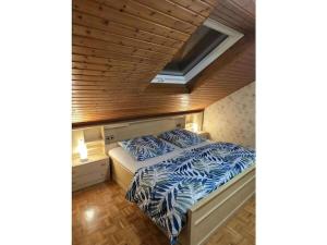 Holiday home Korn am Bärensteig في Bruchweiler-Bärenbach: سرير في غرفة ذات سقف خشبي