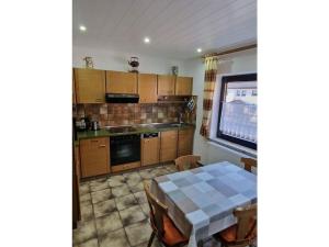 Holiday home Korn am Bärensteig في Bruchweiler-Bärenbach: مطبخ مع طاولة وغرفة طعام