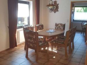 Holiday home Korn am Bärensteig في Bruchweiler-Bärenbach: غرفة طعام مع طاولة وكراسي خشبية +36 صورة