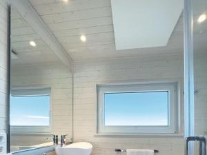 een badkamer met een wastafel, een spiegel en 2 ramen bij Houseboat STERN V in Heiligenhafen