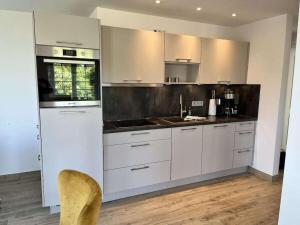 een keuken met witte kasten en een spoelbak bij Penthouse sea view in Lauterbach