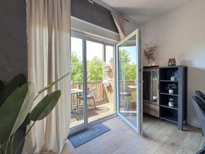 een woonkamer met een glazen schuifdeur naar een patio bij Hirschberg Living in Sankt Wendel