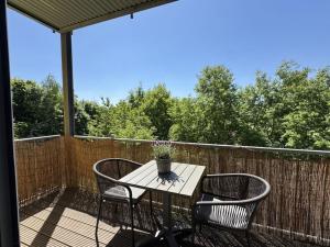 een terrastafel met 2 stoelen en een vaas met bloemen bij Hirschberg Living in Sankt Wendel