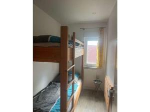 two bunk beds in a small room with a window at Holiday home on Lake Kummerow in Salem