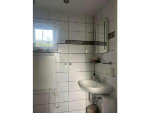 a white bathroom with a sink and a mirror at Holiday home on Lake Kummerow in Salem