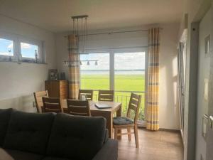 a living room with a couch and a table and chairs at Holiday home on Lake Kummerow in Salem