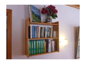 ein Bücherregal voller Bücher an einer Wand in der Unterkunft Hoher Göll in Punzenlehen in Engedey