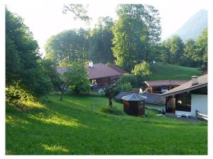 ein Haus auf einem grasbewachsenen Hügel neben einem Haus in der Unterkunft Hoher Göll in Punzenlehen in Engedey + 12 Fotos