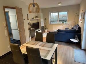 a living room with a table and a blue couch at Alb holiday home Zinnäcker in Trochtelfingen