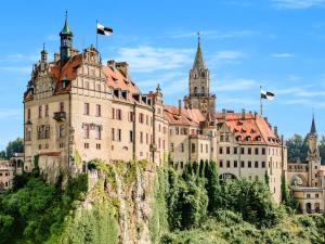 a castle on top of a mountain with flags at Alb holiday home Zinnäcker in Trochtelfingen