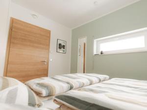 two beds in a room with a door and a window at Alb holiday home Zinnäcker in Trochtelfingen