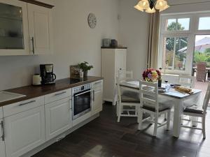 a kitchen with white cabinets and a table with chairs at Manor house apartment in Barlin