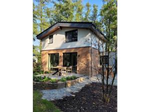 een huisje in het bos met een tafel ervoor bij Holiday home Littard in Rheurdt