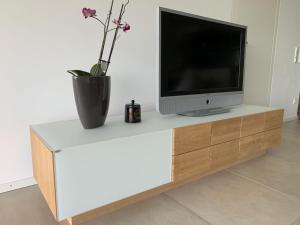 un televisor sentado en la parte superior de un centro de entretenimiento blanco en Holiday apartment with 1 bedroom, en Tannenbach