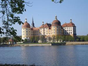 een groot gebouw met koepels aan de oever van een meer bij Log cabin garden in Rabenau