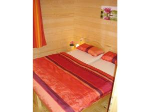 een bed in een houten ruimte met avertisementatronatronstrationstrationstrationstrationstrationstrationstrationstrationstration bij Log cabin garden in Rabenau