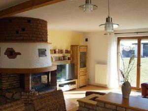 a living room with a brick fireplace and a table at Holiday apartment with 3 bedrooms in Holzendorf