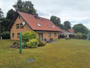 a house with a red roof on a yard at Holiday apartment with 3 bedrooms in Holzendorf