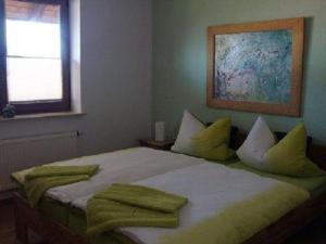 a bedroom with a bed with yellow pillows and a painting at Holiday apartment with 3 bedrooms in Holzendorf