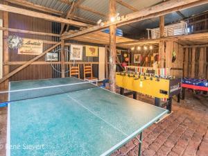 Una mesa de ping pong en una habitación con una pelota de ping pong en Country House Kühren, en Lütjenburg